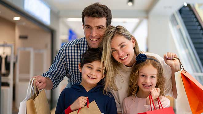 Família com um casal e dois filhos nas compras.
